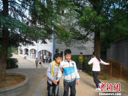 4年來(lái)，13歲的余興泉（左一）每天都攙扶著腿腳不便的同學(xué)左臣進(jìn)出教室、食堂和廁所。 李俊杰 攝