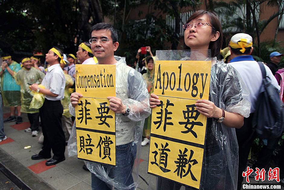 　圖為當天下午，當臺灣數(shù)百漁民在馬尼拉經(jīng)濟文化辦事處前抗議時，有兩名年輕人手持標語，在路邊聲援。中新