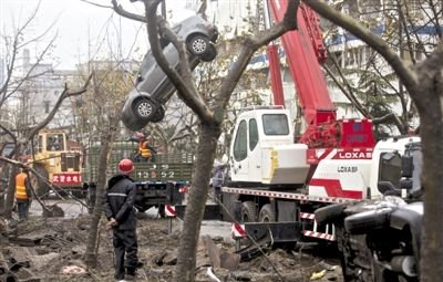 輸油管道爆炸后，搶修人員將被炸毀的車輛運出現(xiàn)場。