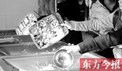 11月27日，河南中醫(yī)學(xué)院餐廳，一名同學(xué)將餐盤內(nèi)沒吃完的食物倒入餐具回收車內(nèi)