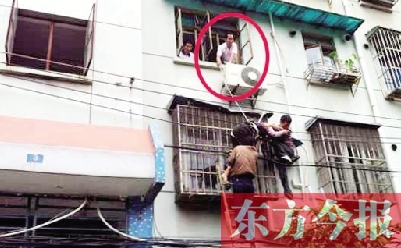 施救現(xiàn)場，劉鵬（圈內）先用繩子捆住老太確保安全 勞動報記者 郭娜 供圖