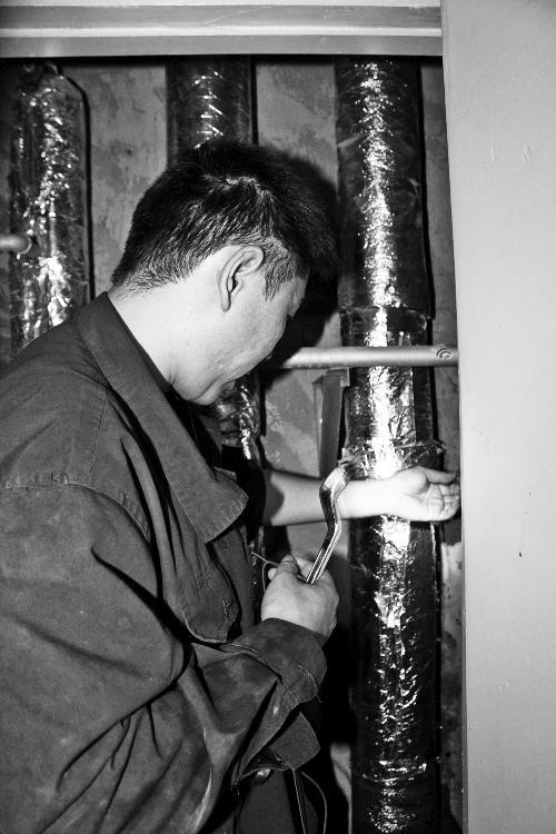 苗師傅一邊進(jìn)行維修，一邊用耳機(jī)接聽市民的電話。