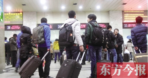 鄭州火車站東廣場(chǎng)售票大廳，幾名學(xué)生在售票窗口前躊躇
