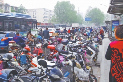 省人民醫(yī)院北門，路邊的公交站牌處停滿非機(jī)動(dòng)車，上、下客只能在快車道上。