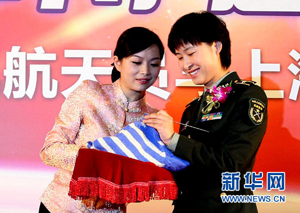 11月1日，航天員劉洋（右）在為“愛(ài)心”毛衣編織最后的收尾針。