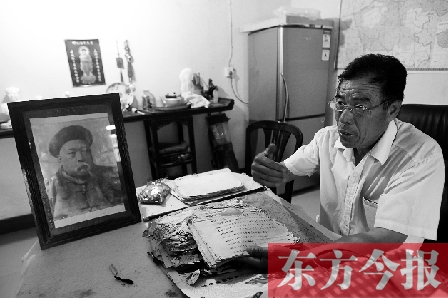 　魏樹紹手拿《物權法講義》手稿，在講訴先祖書寫“物權法”的歷史（相框里就是魏聯(lián)奎）