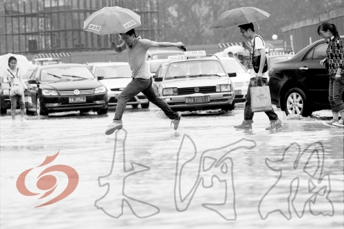 鄭州經(jīng)三路與北環(huán)交叉口處，積水較深，行人們不得不“練輕功”。 記者 白周峰 攝影