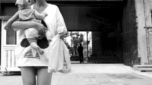 抱著孩子出售人奶的女子。
