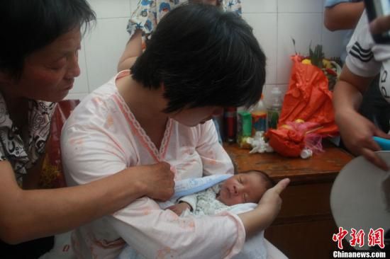 圖為陜西富平“產(chǎn)科醫(yī)生拐賣嬰兒”一案中的被拐嬰兒于8月5日中午在該縣婦幼保健院由當(dāng)?shù)鼐浇挥谄涓改?。張一?攝