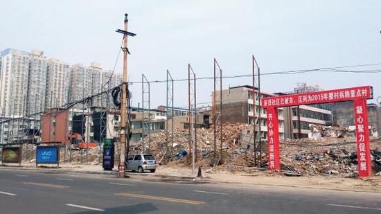 015年5月31日，在社區(qū)干部的帶頭拆遷下，親賢社區(qū)的“城中村改造”拉開帷幕。由于前期“清產(chǎn)核資”及補(bǔ)償標(biāo)準(zhǔn)等因素，拆遷改造工作推進(jìn)并不順利。圖為位于體育西路東側(cè)集體所有的商鋪率先被拆遷完畢，用于遮擋的圍擋正在施工中。（拍攝：2015年9月16日）