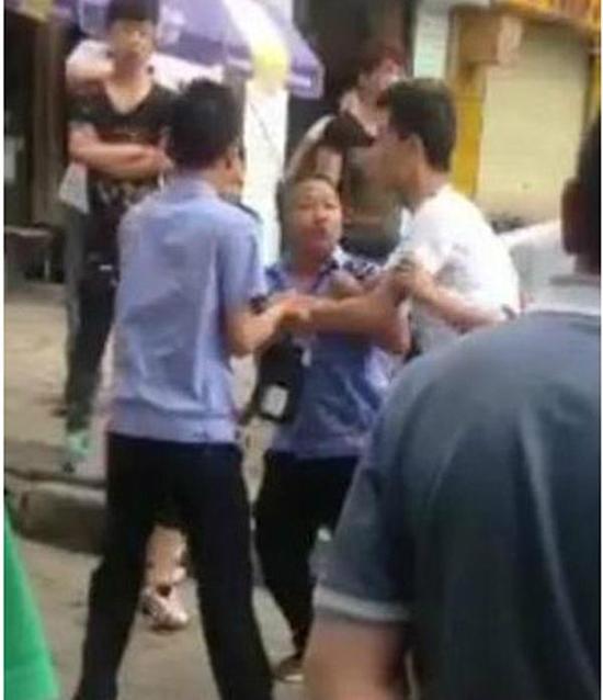 付某（右）與城管執(zhí)法人員廝打在一起。