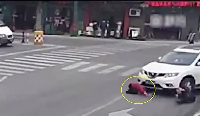 圖為小姑娘被卷進(jìn)車輪下瞬間。