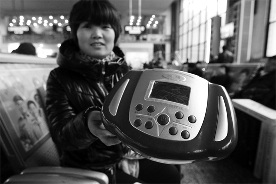 火車站候車室，李女士向記者展示她準(zhǔn)備孝敬父母的按摩儀