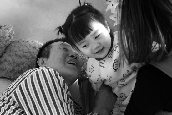 病床前李剛父女倆說著“悄悄話”，幸福的氣氛洋溢在病房中