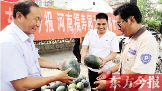 河南福壽園區(qū)域總經(jīng)理吳正宗（左一）、東方今報(bào)發(fā)行中心副總監(jiān)王路喜（中）在街頭給市民送瓜