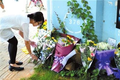 6月8日下午，記者來到廈門公交車爆炸事發(fā)現(xiàn)場橋下，附近已聚集了十幾個自發(fā)前來悼念的市民。橋墩下排放了一圈或黃或白的菊花，還有玖瑰、百合等。