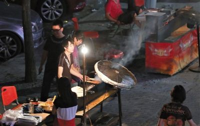 7月4日，青年路國(guó)美第一城小區(qū)附近的夜市臨街露天燒烤攤。