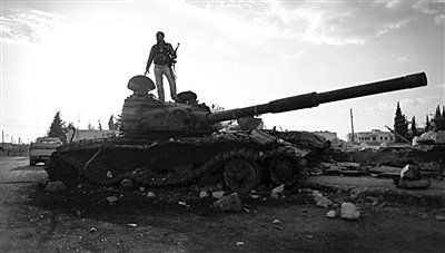 9月8日，敘利亞Zabadani，一名敘利亞反對派武裝人員站在廢棄的政府軍坦克上。