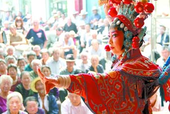 圖為8月15日戲曲演員在“流動(dòng)舞臺(tái)車”上表演傳統(tǒng)地方戲《穆桂英下山》。