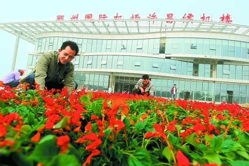 9月23日，工人們正在鄭州國際機(jī)場許昌候機(jī)樓前擺放鮮花。