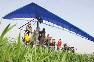 　　4月12日，在武陟縣北郭鄉(xiāng)韓余村，一架三角翼動(dòng)力滑翔機(jī)在對小麥進(jìn)行農(nóng)藥噴灑作業(yè)。為提升農(nóng)業(yè)生產(chǎn)的