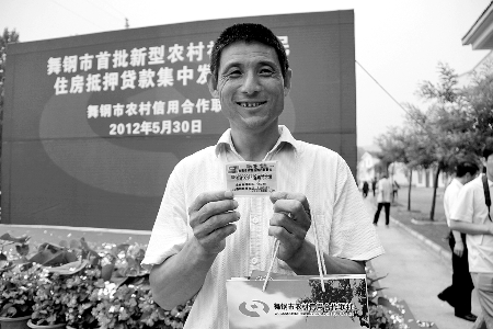 領(lǐng)到貸款，農(nóng)民開(kāi)心地笑了。