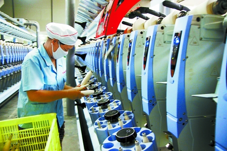 7月3日，在鄧州市永泰棉紡有限公司電腦控制全自動紡紗車間，紡織工人正在生產(chǎn)棉紗。