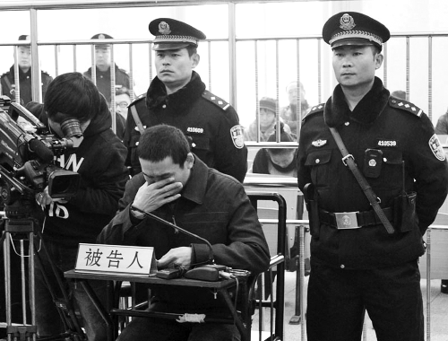 庭審中,29歲的李軍低著頭。