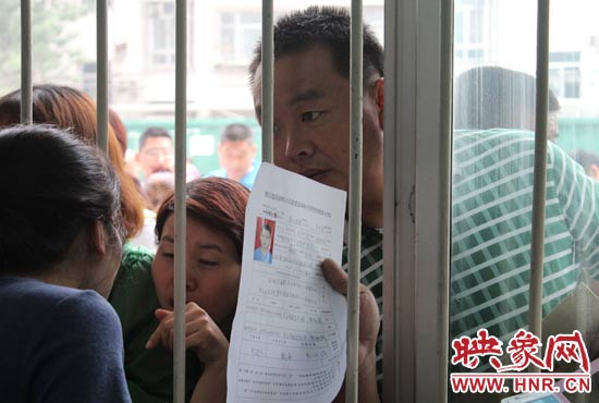 不少家長(zhǎng)擠在報(bào)名窗口前咨詢報(bào)名事宜。