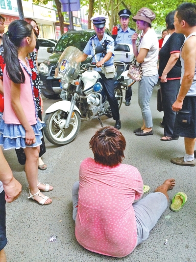 在鄭州優(yōu)勝南路東三街交叉口向東100米處，一名短發(fā)中年女子平躺在路南快車道上，身旁還有一只掉落的拖鞋
