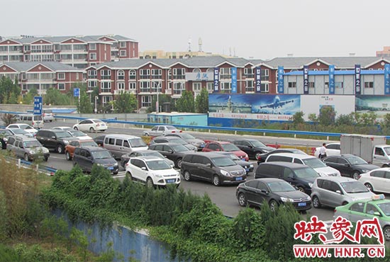 記者看到鄭州機場收費站口車輛排隊，與此形成鮮明對比的是，路的對面（另一半幅）卻車輛較少，通行順暢。