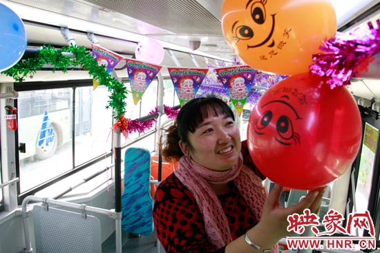 鄭州快速公交B3區(qū)間線車長李鵬云在車廂里懸掛氣球，布置圣誕車廂，營造歡樂圣誕氛圍