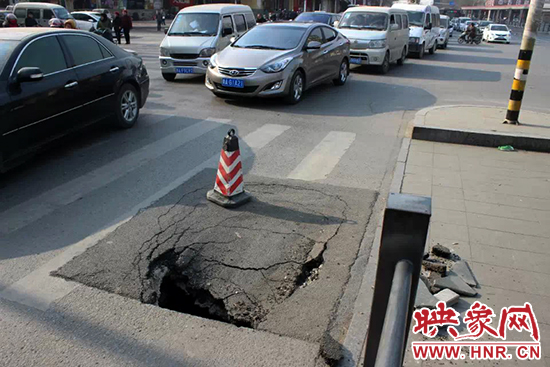 南陽路農(nóng)業(yè)路出現(xiàn)深坑，近看是因?yàn)闉r青充當(dāng)窨井蓋所致