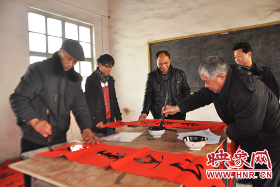鞏義市魯莊鎮(zhèn)農(nóng)民書法愛好者正在寫春聯(lián)。
