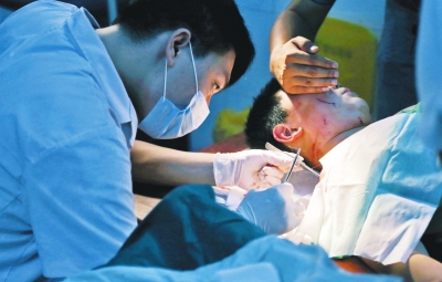 孩子身上有7道傷痕，其中兩道需要縫合，其他的均為擦傷，醫(yī)生正對(duì)他施治。
