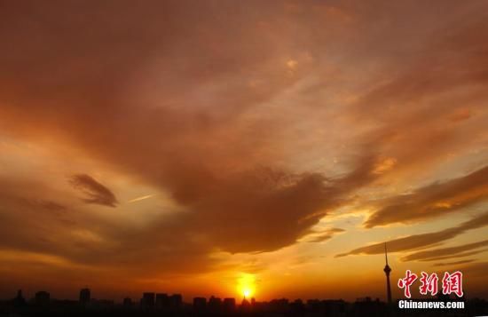 12月8日下午，強(qiáng)烈的西北風(fēng)光臨北京，吹散了籠罩全城上空的霧霾，冬日罕見的艷麗晚霞映紅了半邊天。