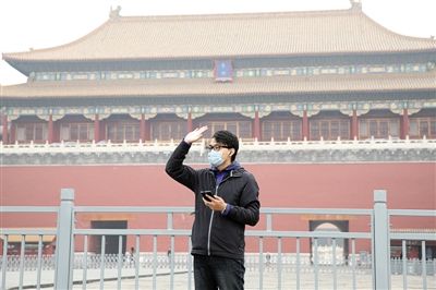 11月1日，北京大部分地區(qū)重度污染，一名游客戴著口罩在午門(mén)前揮手跟朋友打招呼。 實(shí)習(xí)生 王飛 攝