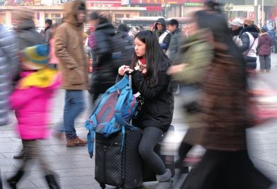 春運(yùn)首日，北京站客流量明顯增多，一名女孩在人流中等待進(jìn)站。