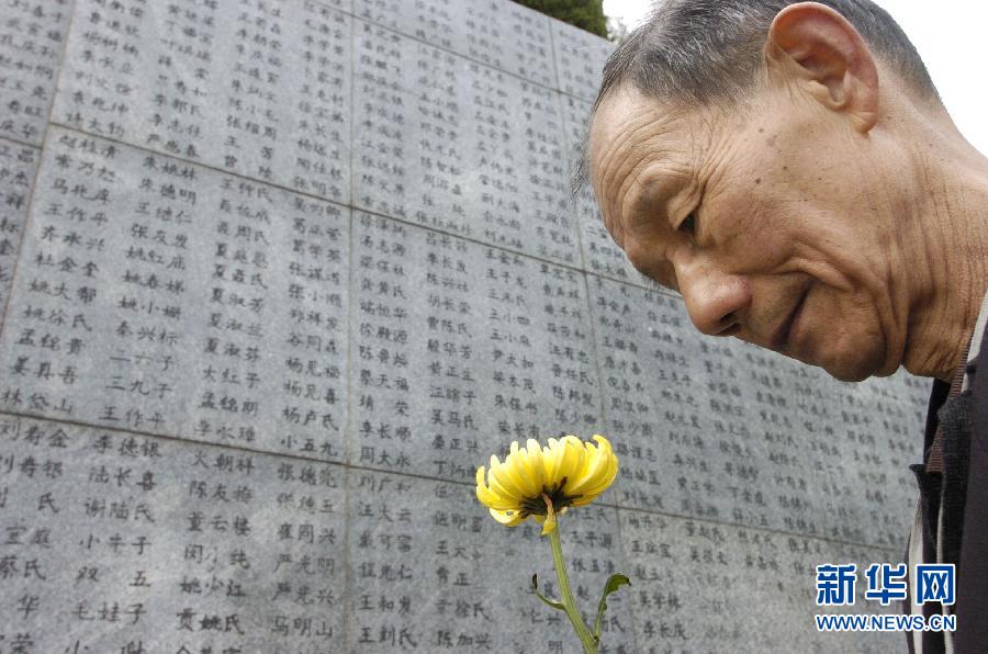 2006年4月5日，74歲的南京大屠殺幸存者佘子清手捧鮮花，祭奠被日軍殺害的母親。