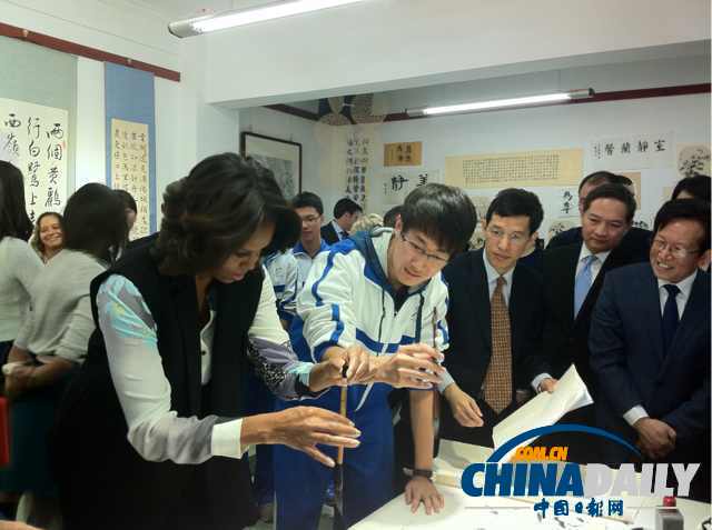 北京時間3月21日，美國第一夫人米歇爾參觀北師大二附中時，與學(xué)生一起練習(xí)書法。