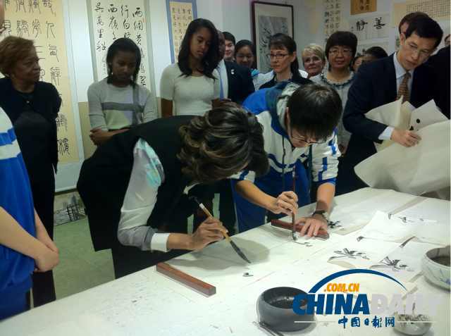 　北京時間3月21日，美國第一夫人米歇爾參觀北師大二附中時，與學(xué)生一起練習(xí)書法。