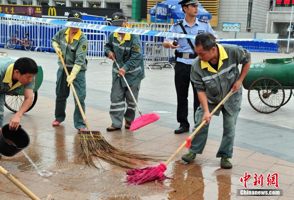 圖為環(huán)衛(wèi)工人在清理案發(fā)地點(diǎn)的血跡。