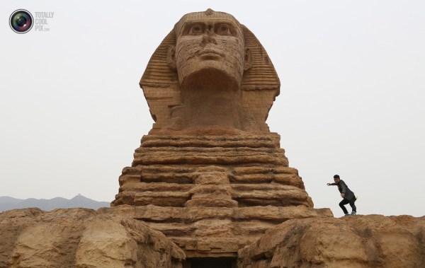 石家莊郊外，一名男子與山寨版獅身人面像合影留念。