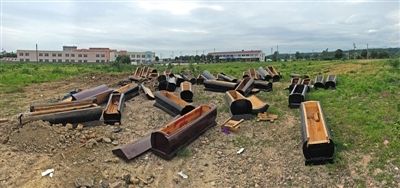40多副棺木被砸壞后，扔在荒地上。