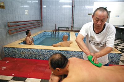 客人在搓澡。近日，百年歷史的鑫園浴池宣布將關(guān)張。新京報(bào)記者