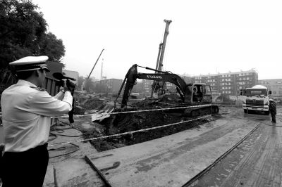 學(xué)院南路一科研樓項目有3臺挖掘機(jī)違規(guī)進(jìn)行土方作業(yè)，被城管隊員當(dāng)場責(zé)令停工。京華時報記者歐陽曉菲攝