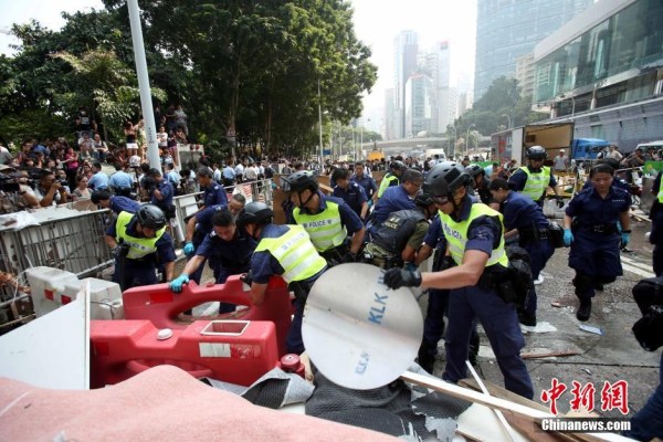 10月14日，警方清除金鐘道障礙物。大批警員在金鐘道現(xiàn)場清拆障礙物。部分警員戴上頭盔將障礙物移走。