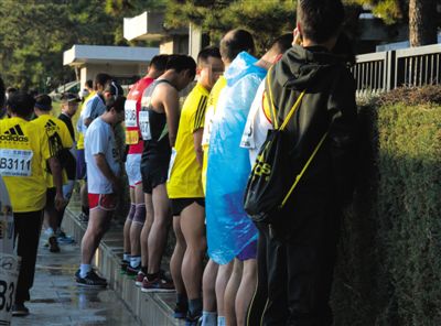 2013年10月20日，北京馬拉松比賽，由于廁位有限，一些選手在綠化帶“就地解決”。圖/IC
