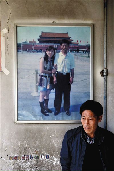 11月14日，承德市平泉縣，潘小梅父母的家，潘小梅父親靠在墻上，身后掛著數(shù)年前他和潘小梅在北京的合影照片。新京報記者