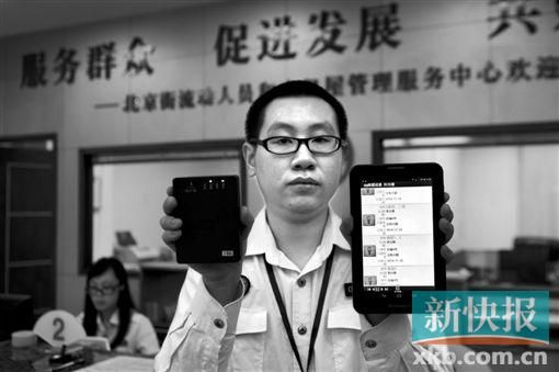 　越秀區(qū)北京街出租屋外來暫住人員管理服務(wù)中心的工作人員展示到出租屋登記來穗人員信息的儀器。